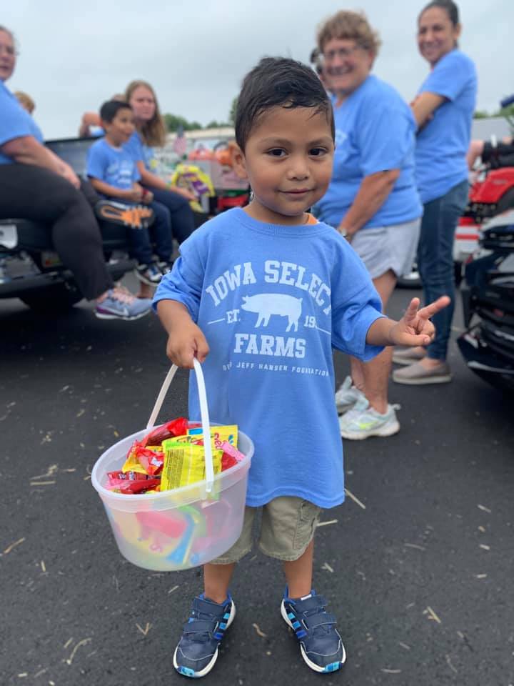 A child poses with candy and throws a peace sign to the camera.