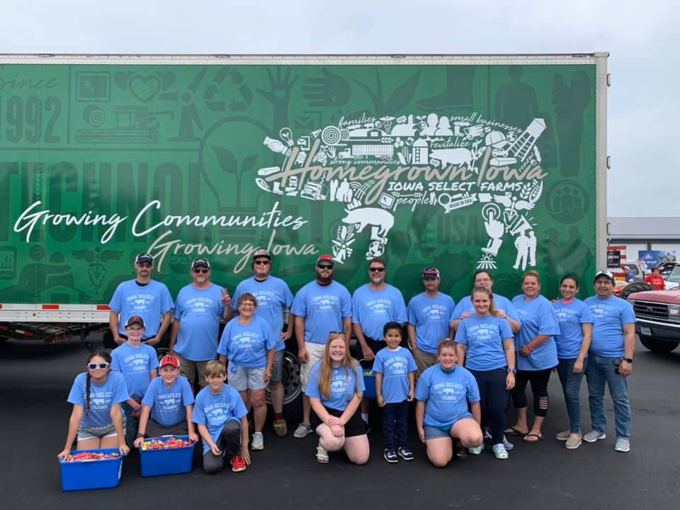 A group of parade participants stand in front of an Iowa Select semi for a group picture.