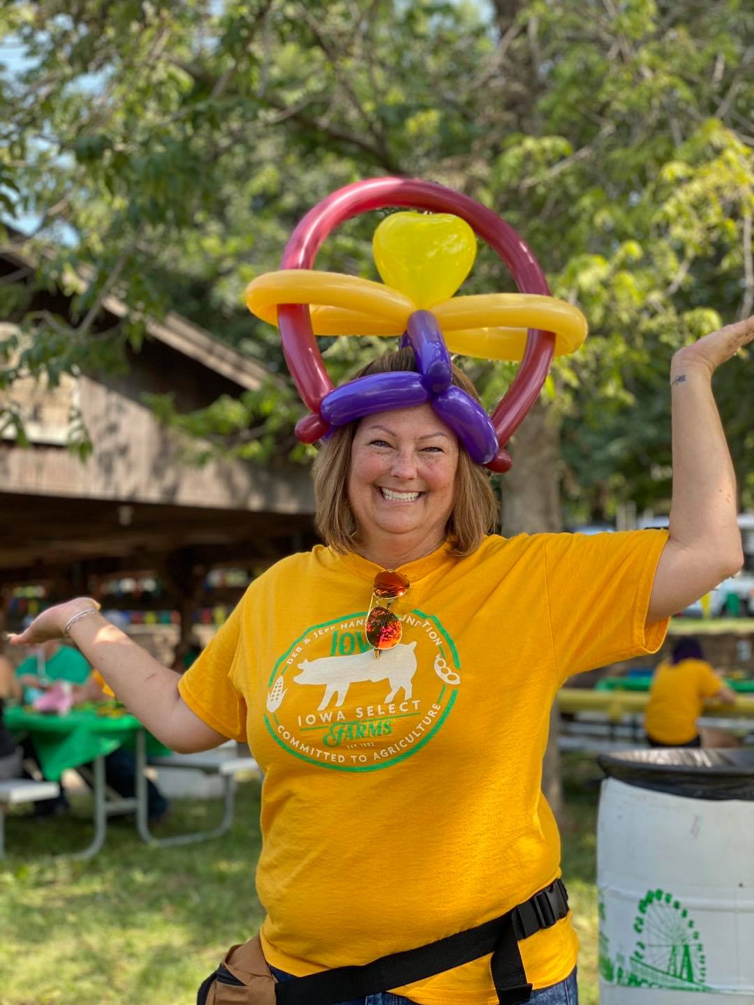 A woman poses while wearing a balloon hat.