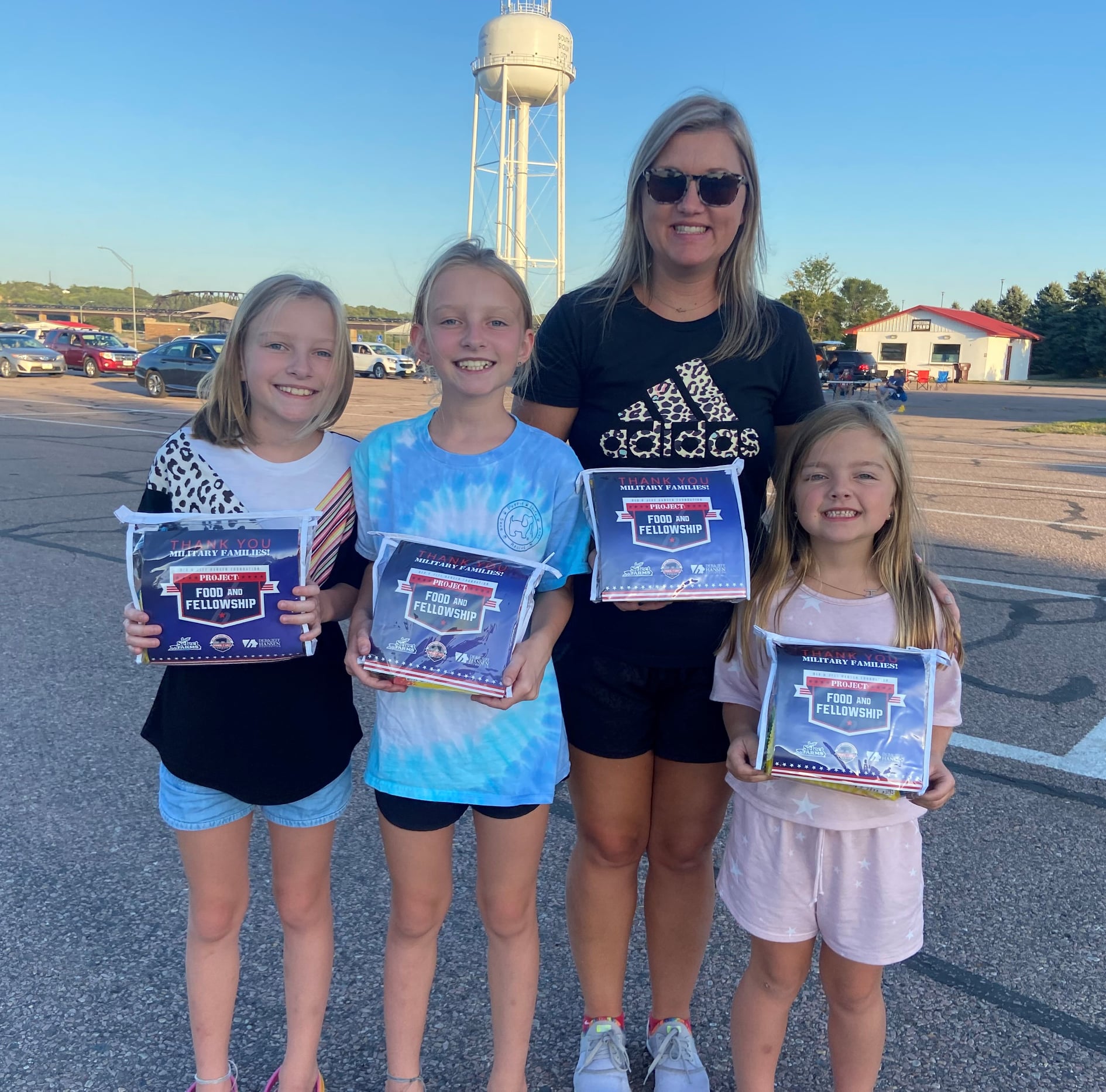 A family holds family fun movie packs provided by the Deb and Jeff Hansen Foundation.