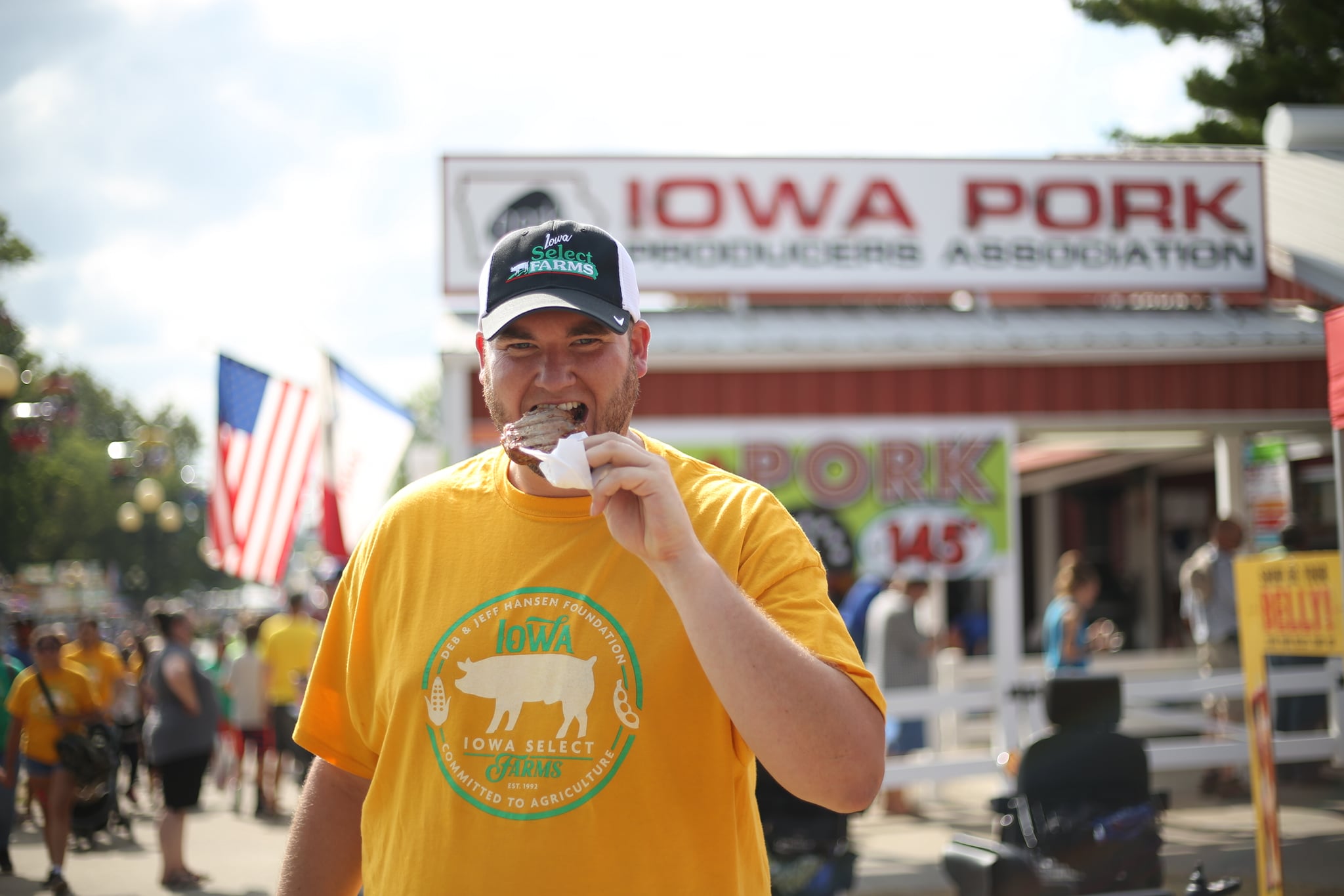 Ezra takes a bite of a pork chop outside the Iowa Pork tent.