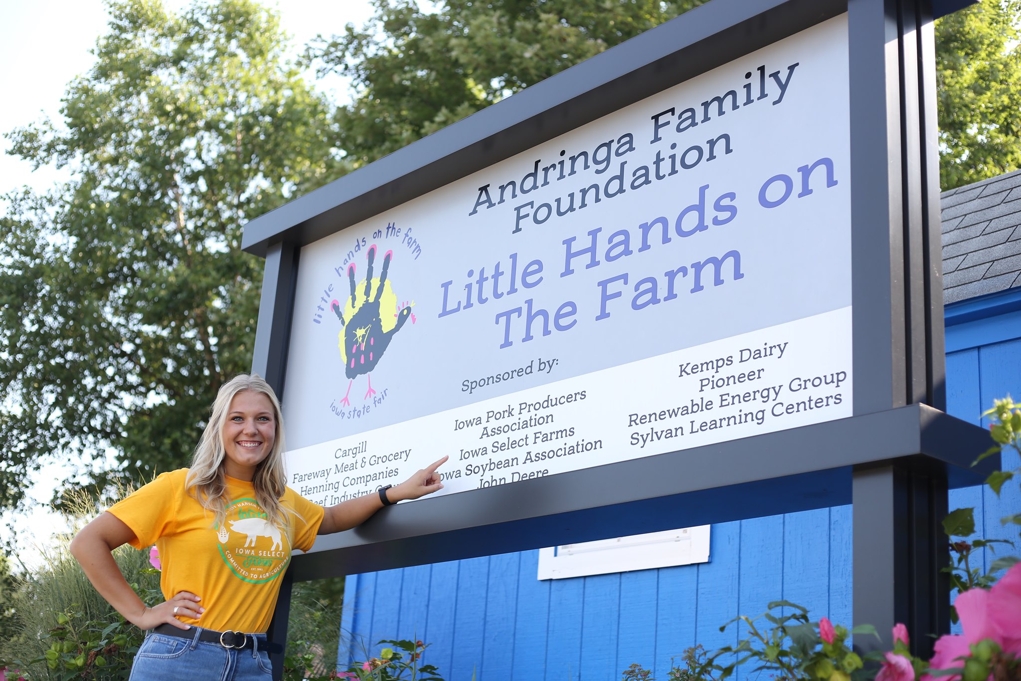 Eleanor poses by the Little Hands on the Farm sign.
