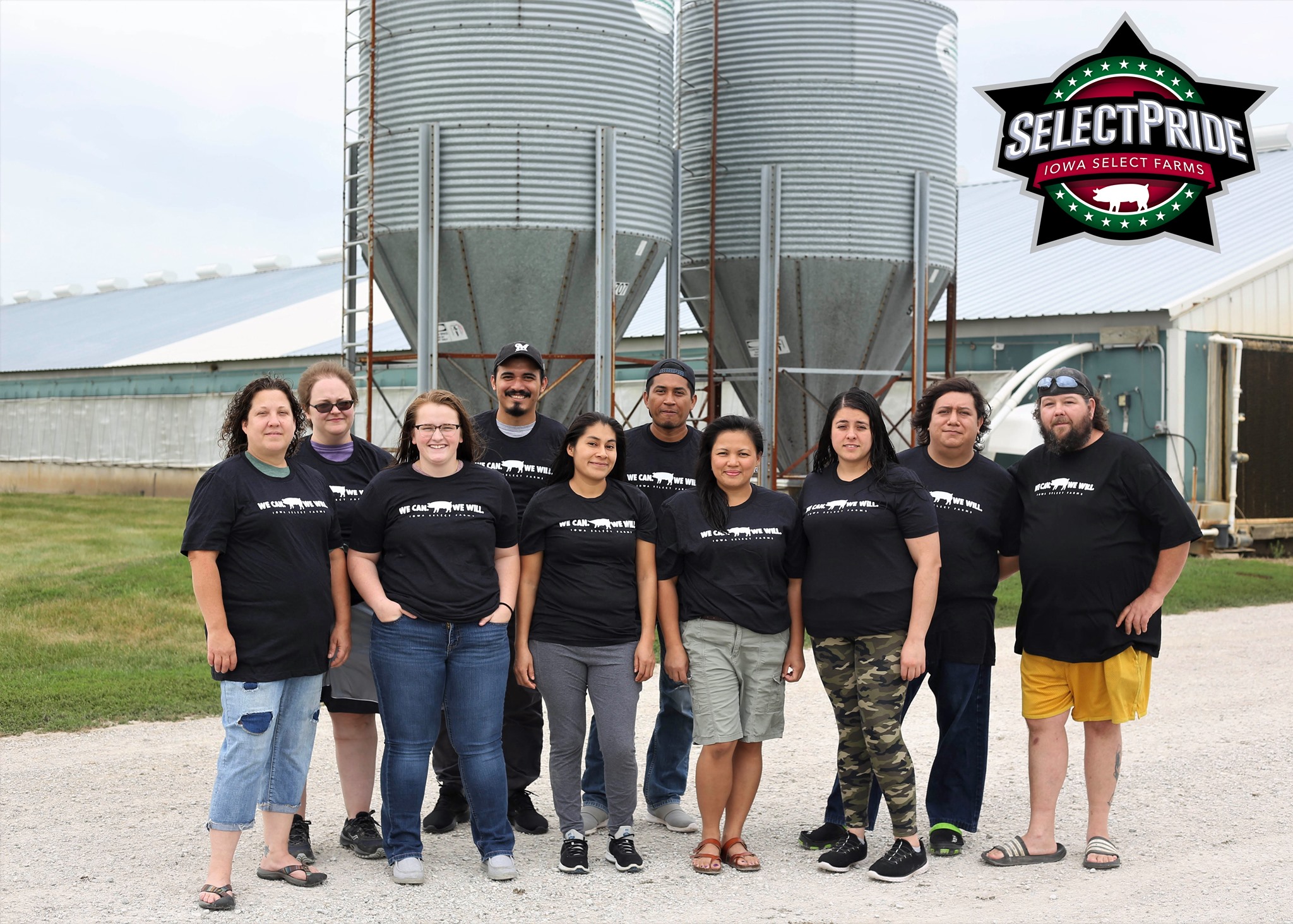 The farm team stands outside of the barn,