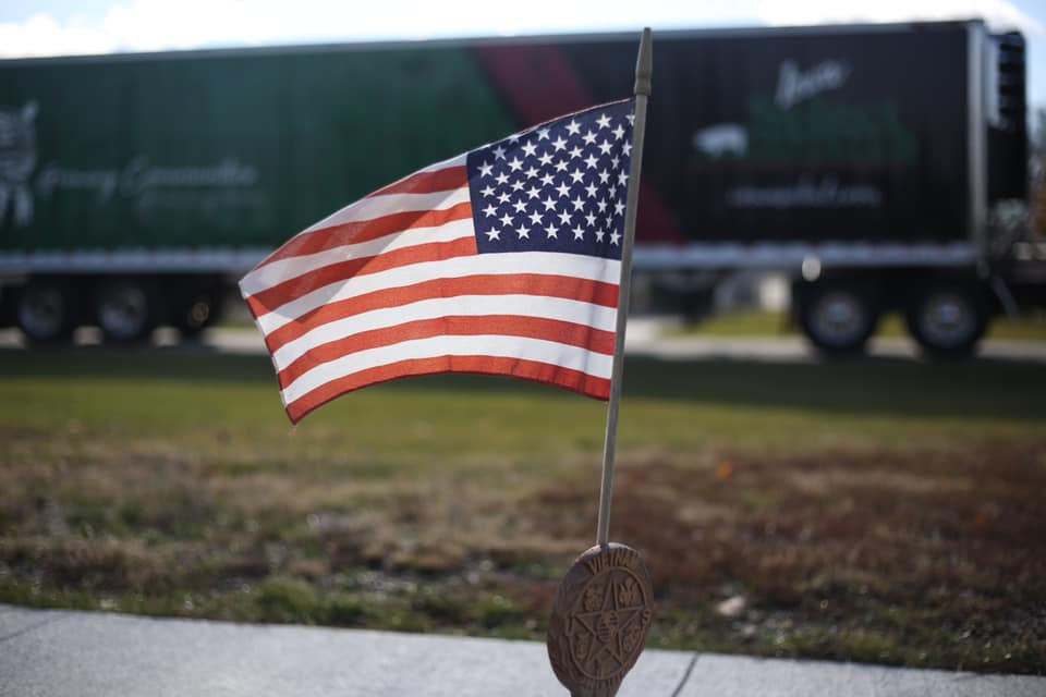 a flag waves in front of an Iowa Select semi