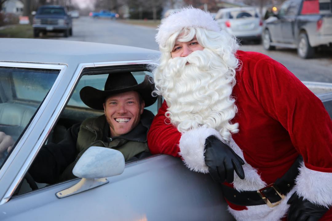 Santa poses with man in car