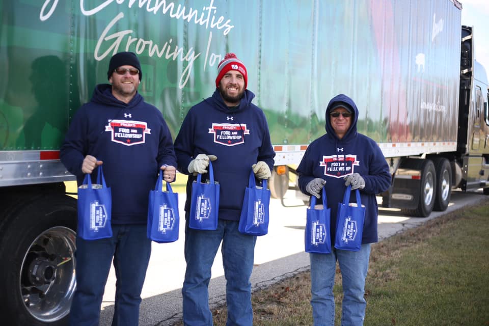 Three volunteers hold pork loins