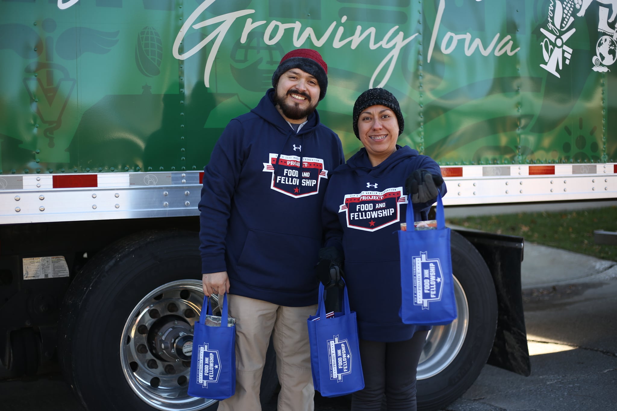 Two employee volunteers hold pork loins