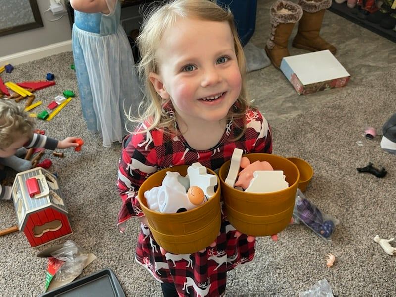 a young girl holds agriculture toys