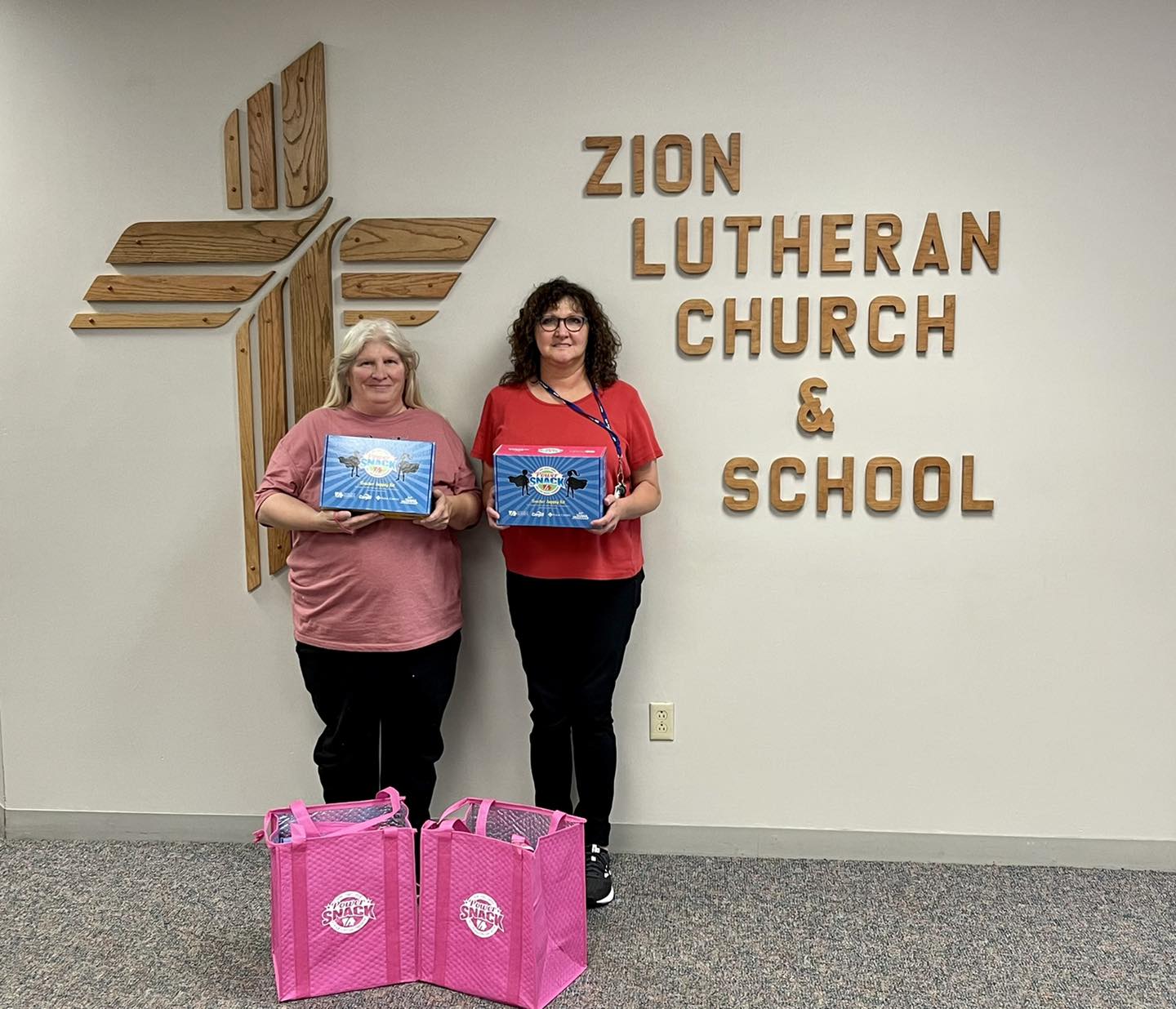 Zion Lutheran Church and School emp. holding Power Snack boxes