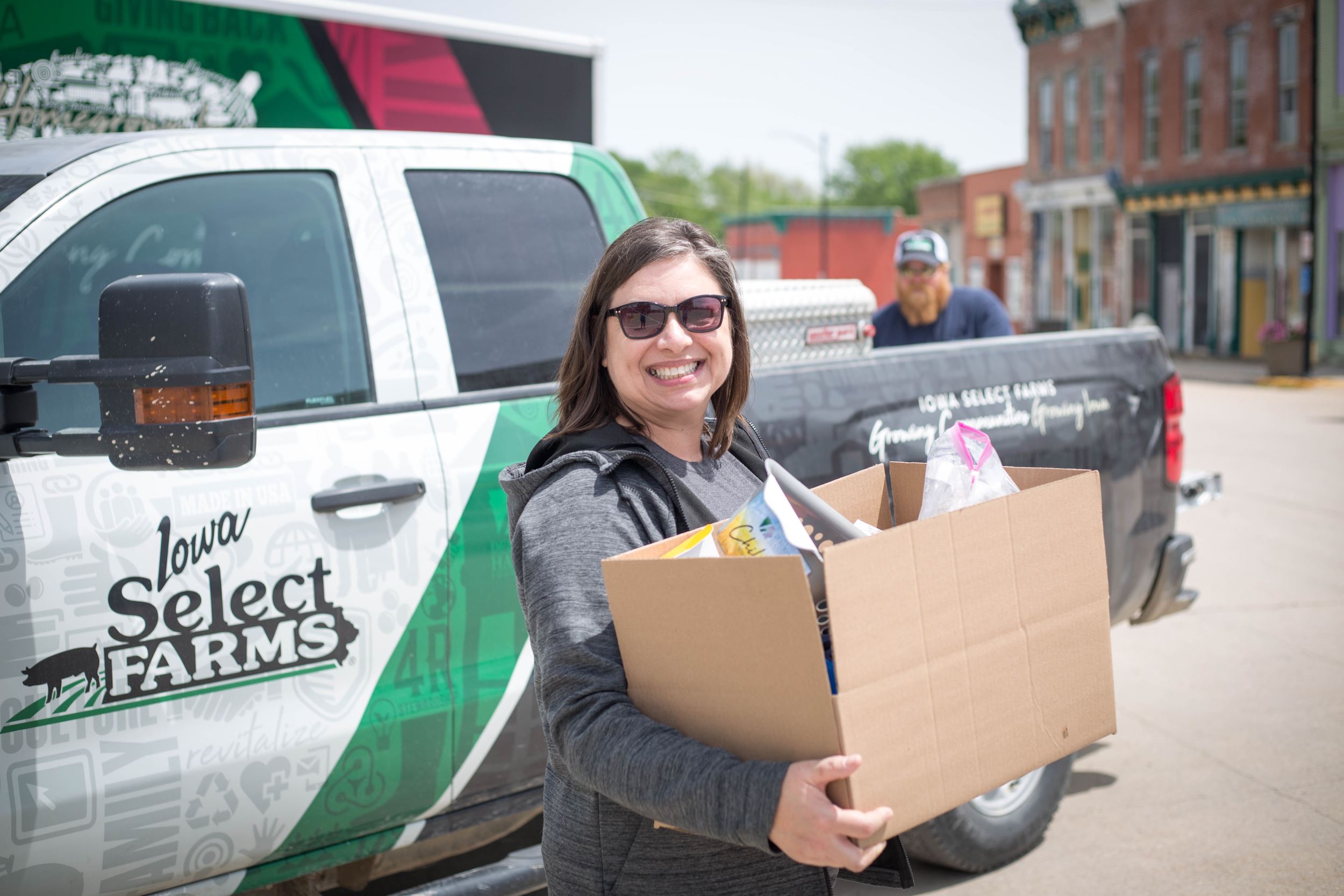 Julie holds a box of supplies for her little free pantry.