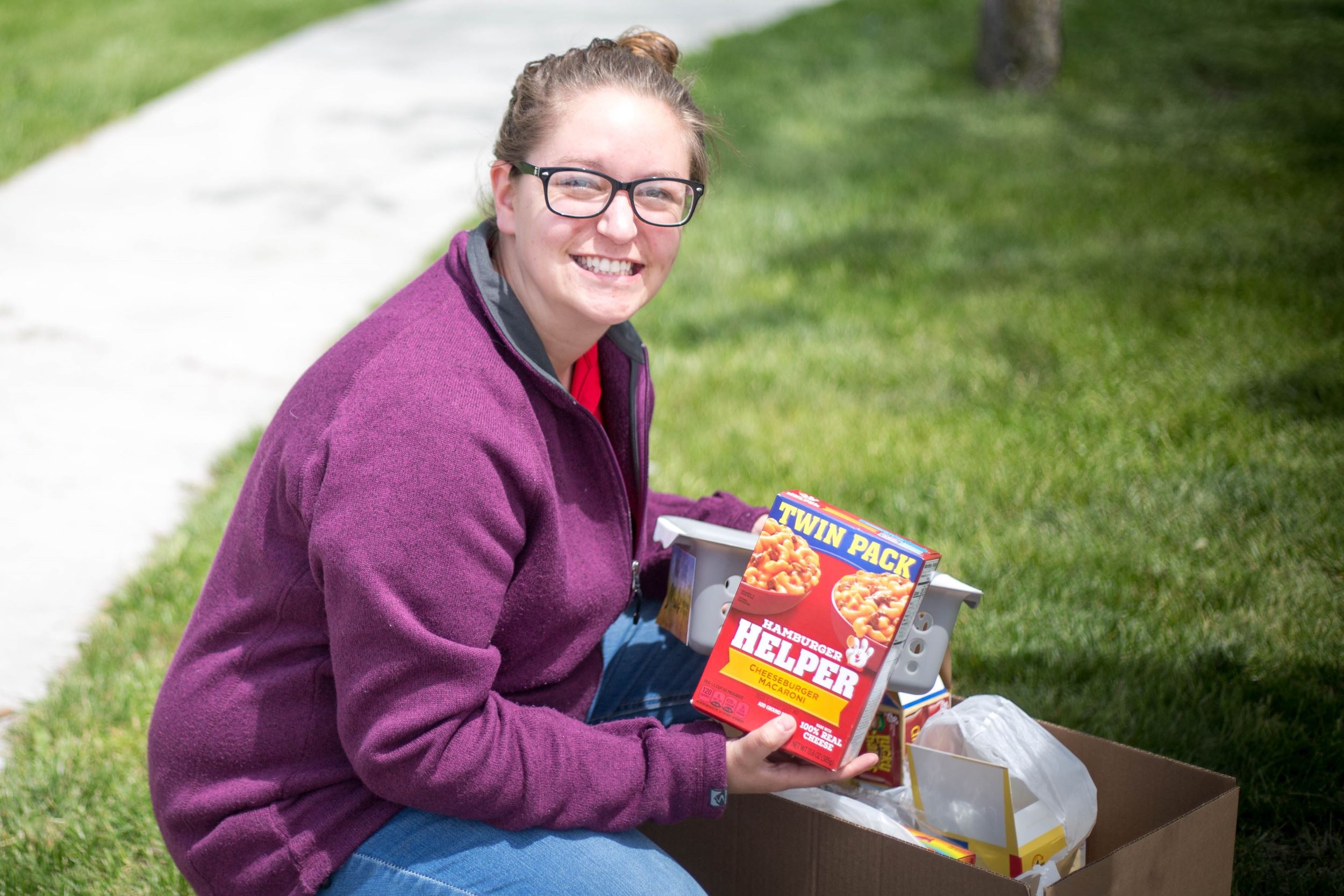 T'Lee holds a box of food for her pantry