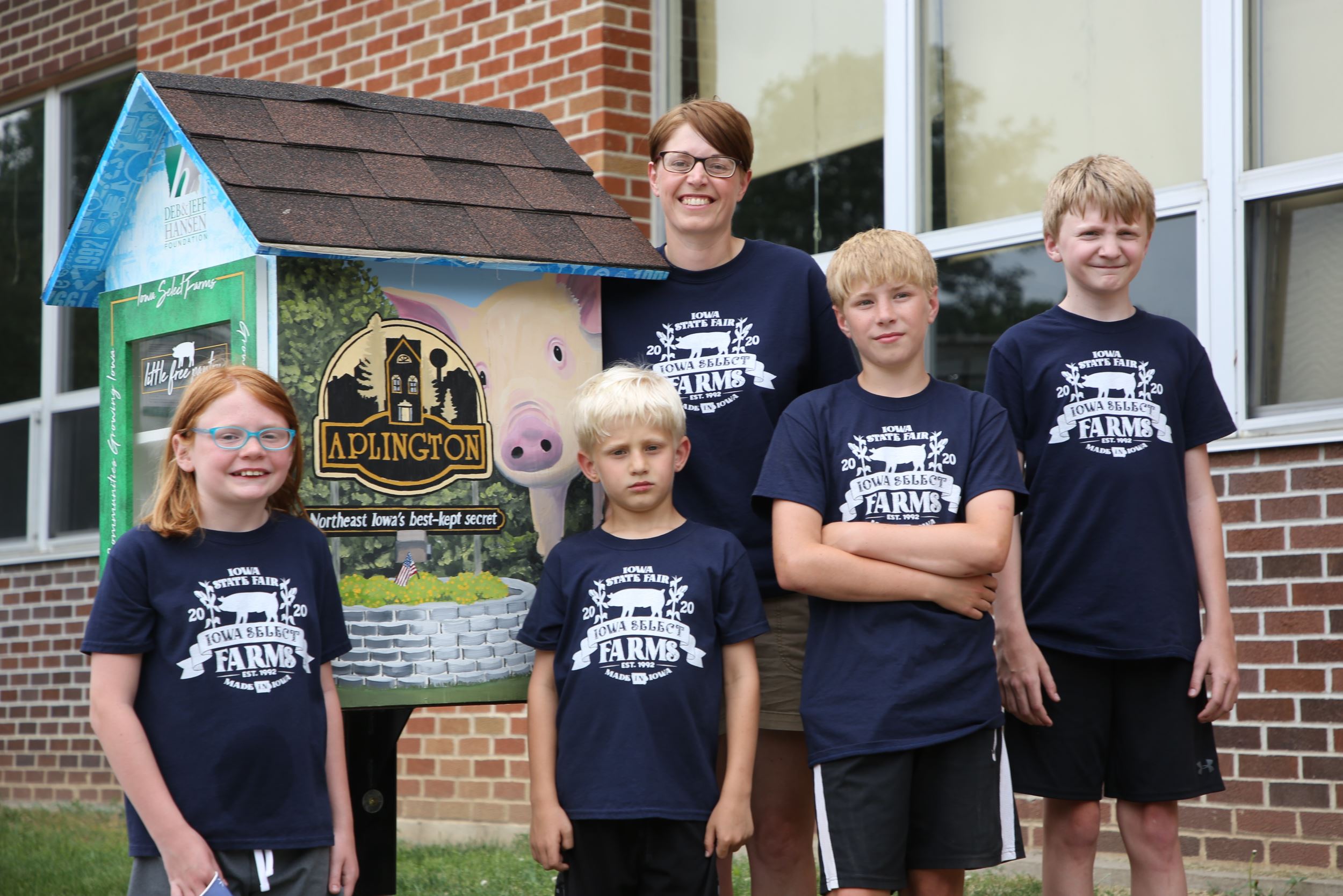Brooke and her kids pose in front of their pantry.