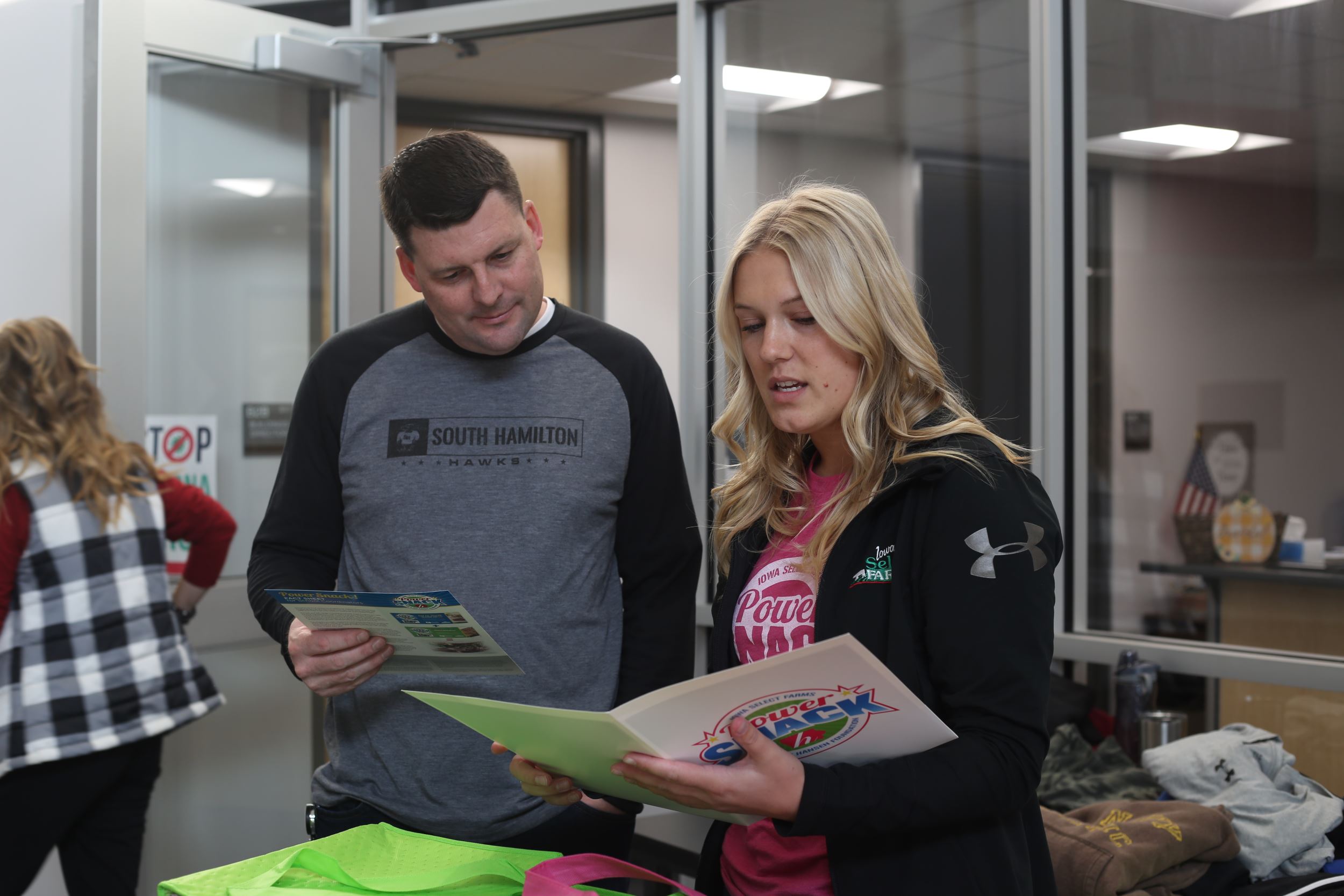 A school administrator and Eleanor look at Power Snack papers