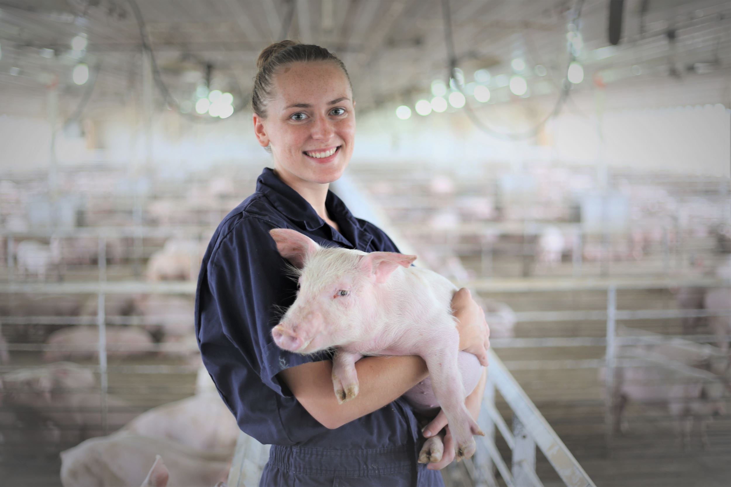 Katie holds a pig in a finisher.