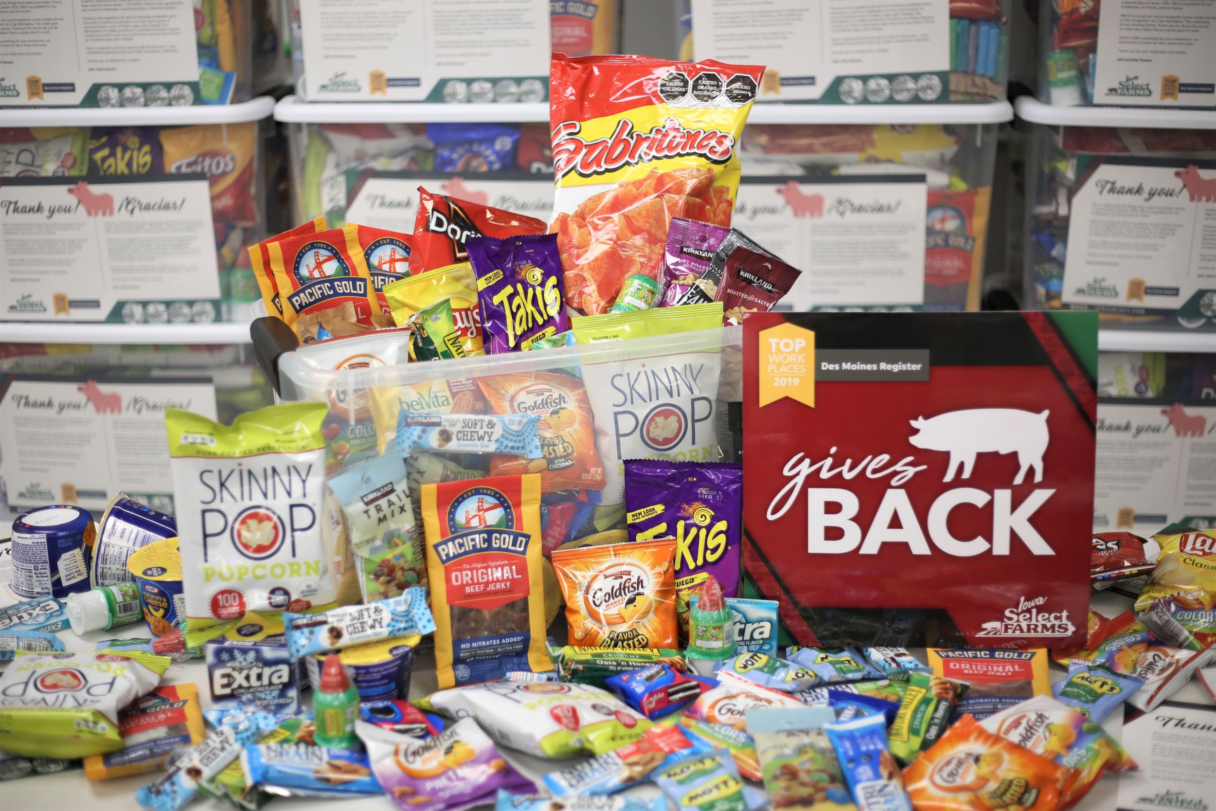A collection of food and snacks with a red gives back sign.