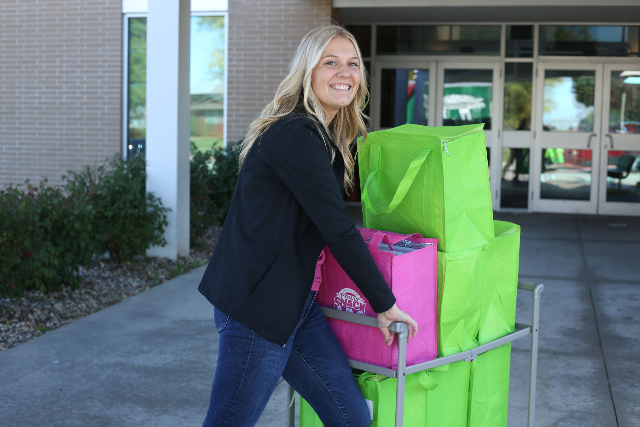 eleanor pushes bags to a school