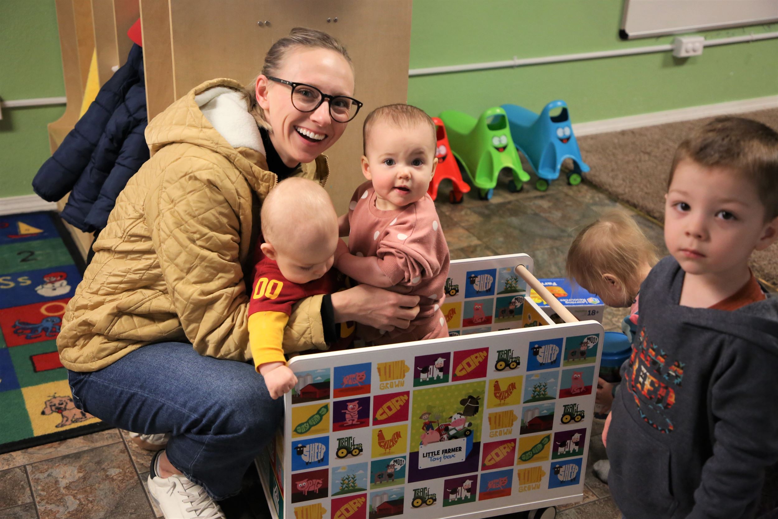 erica holds two babies in a toy box