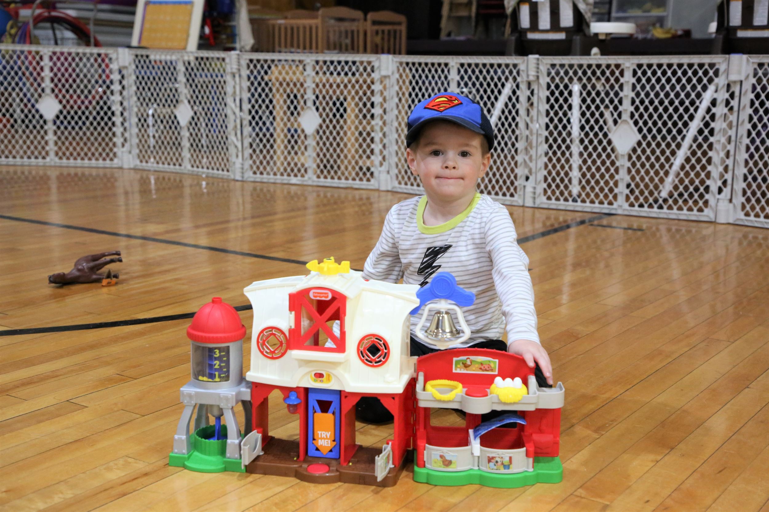 child with toy barn