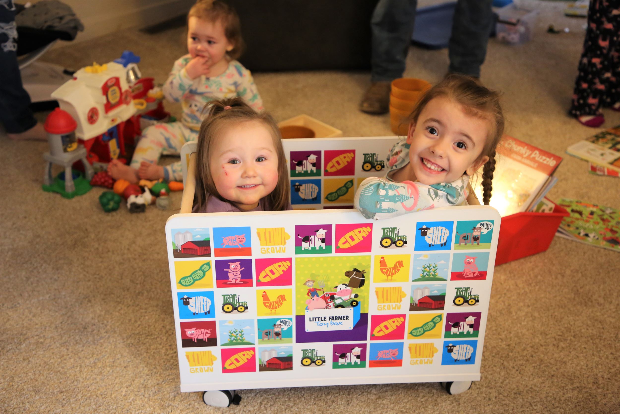 two kids sit in toybox