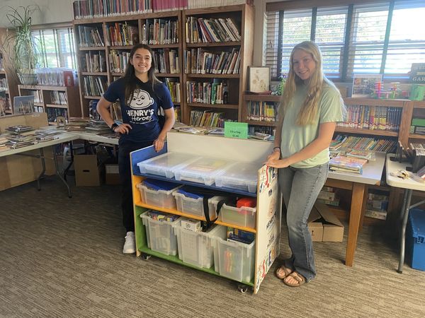 Reagan and Brielle standing by cart