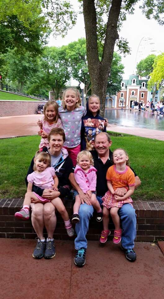 mark poses with his wife and grandkids