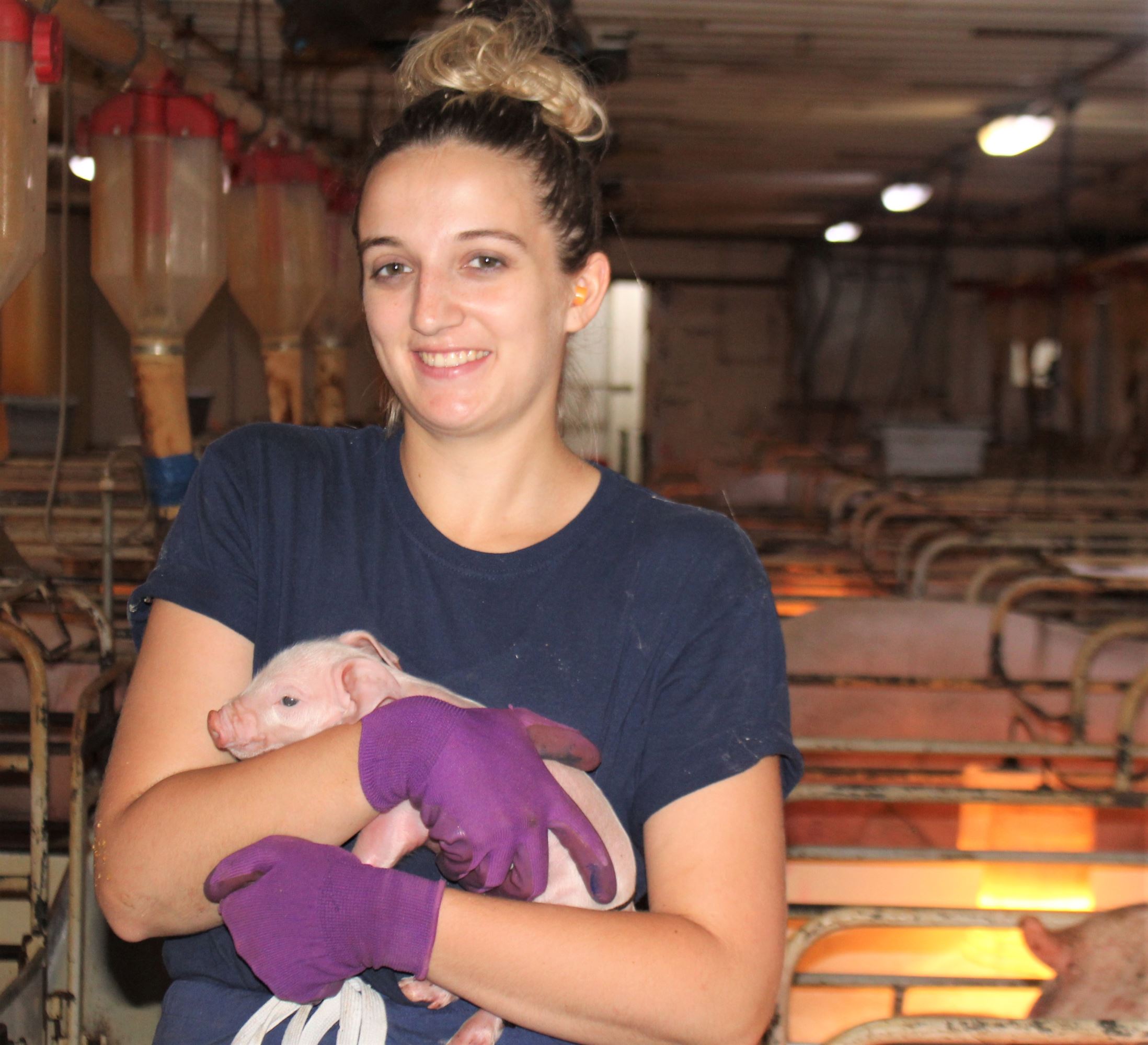 Addisyn holds a baby pig.