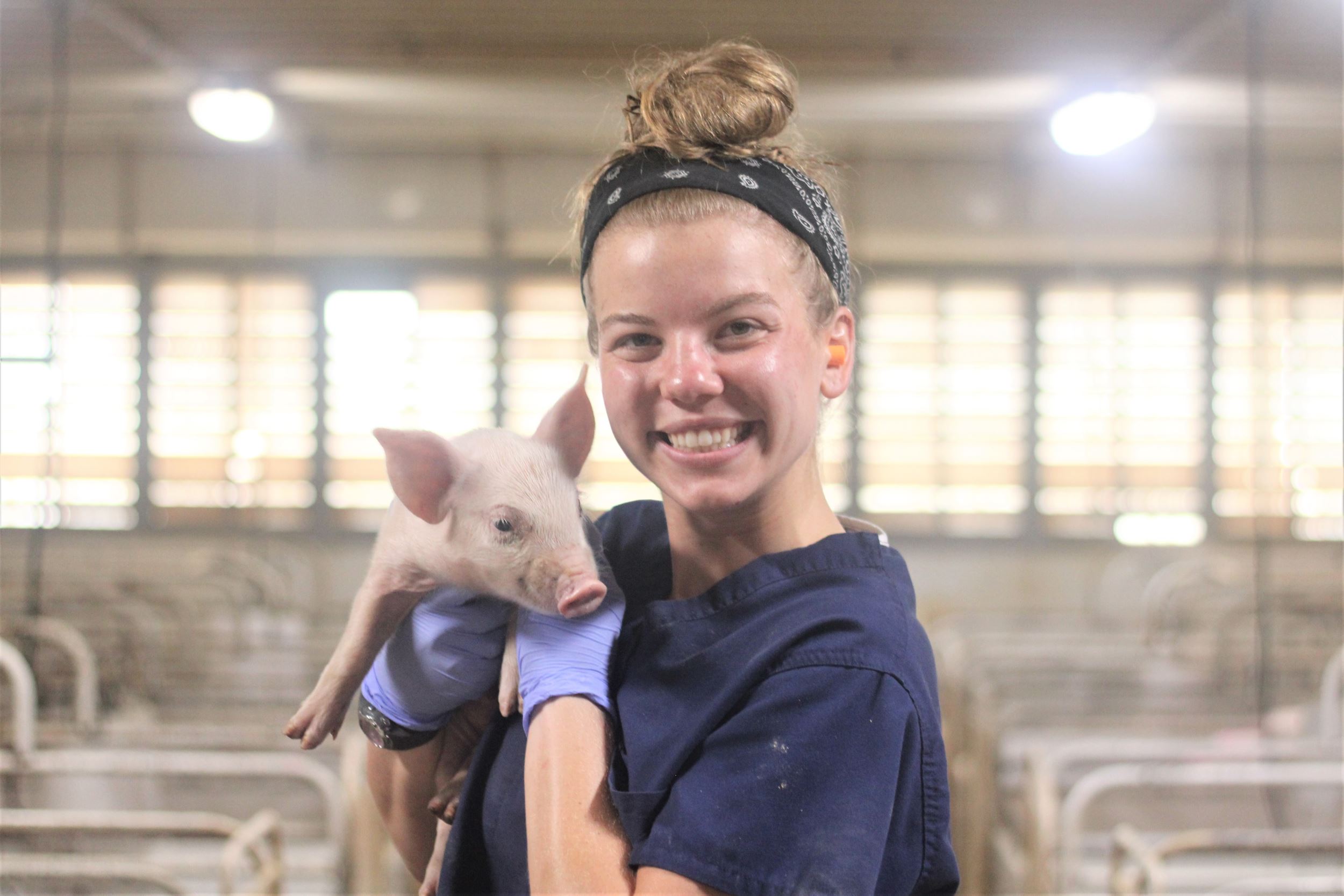 Emily holds a wean pig.