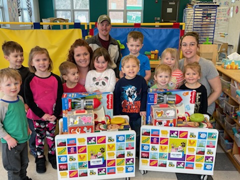 Group poses with toybox