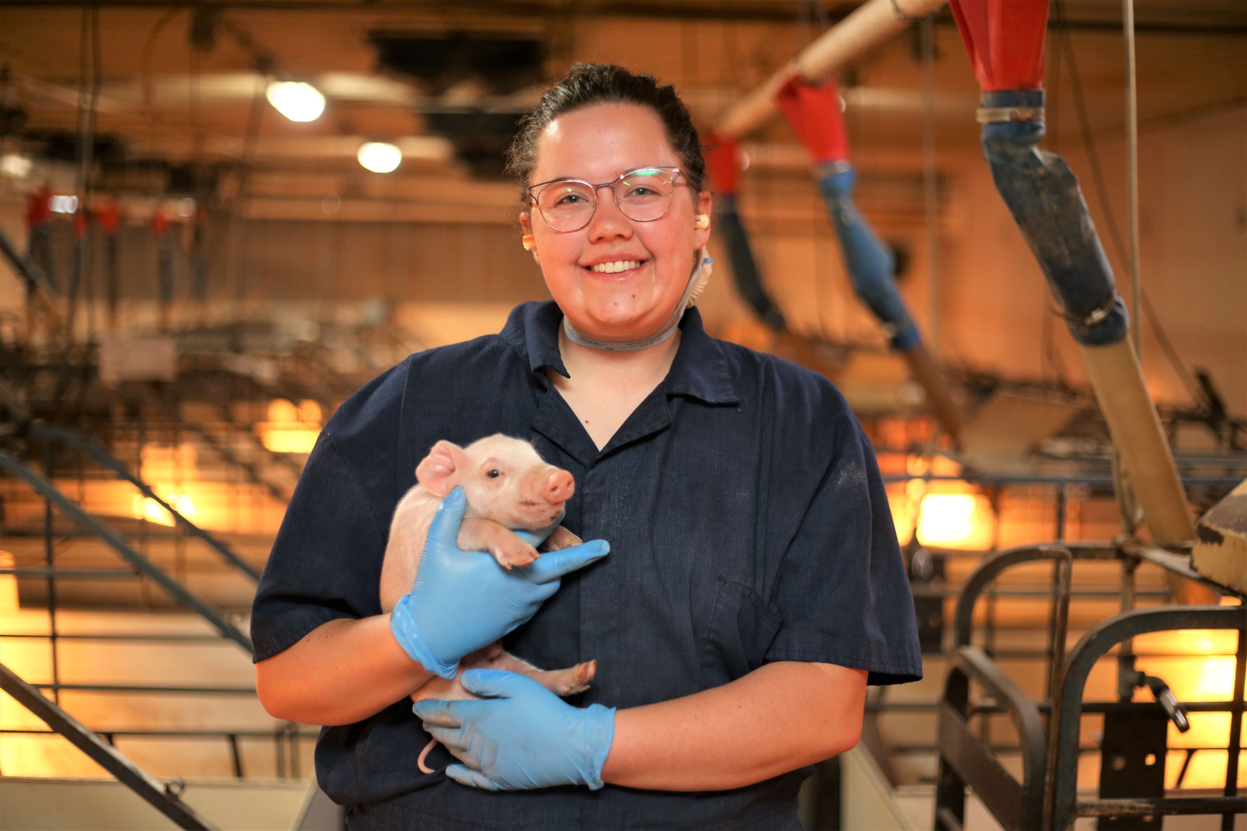 Kiley holds a baby pig.