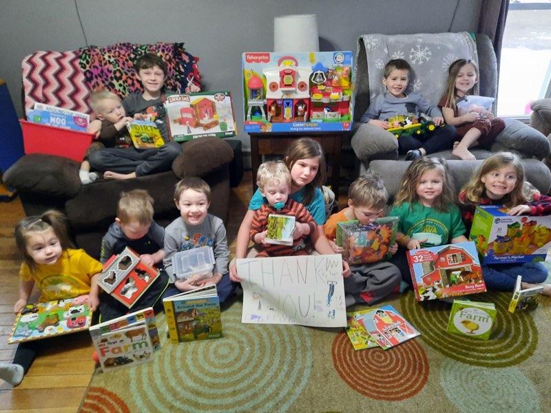 kids take a group photo by toy box with toys