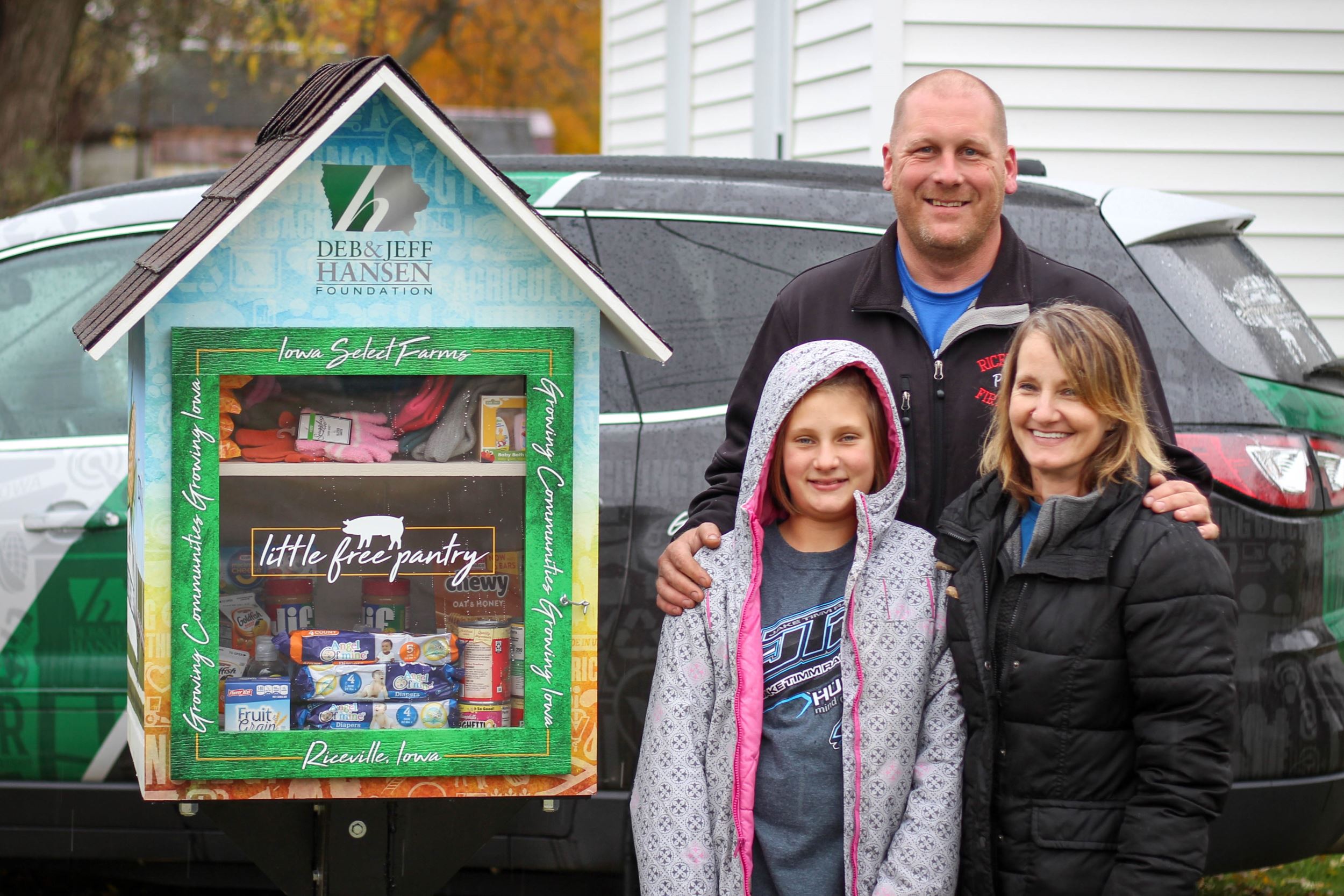 Family stands by little free pantry