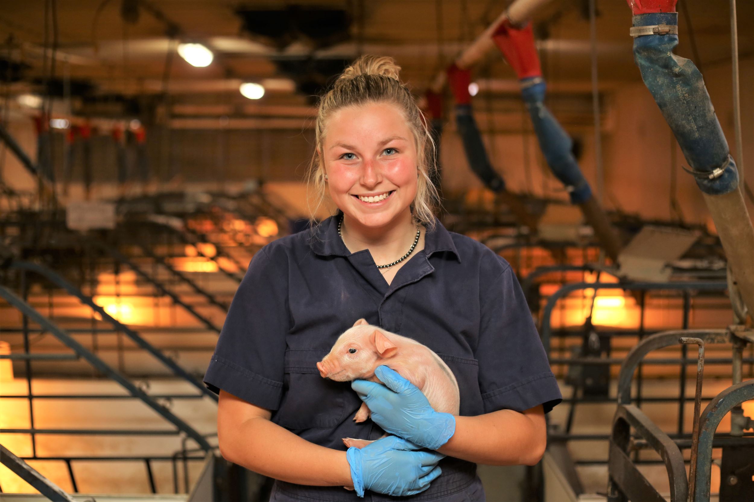 Riley holds a piglet