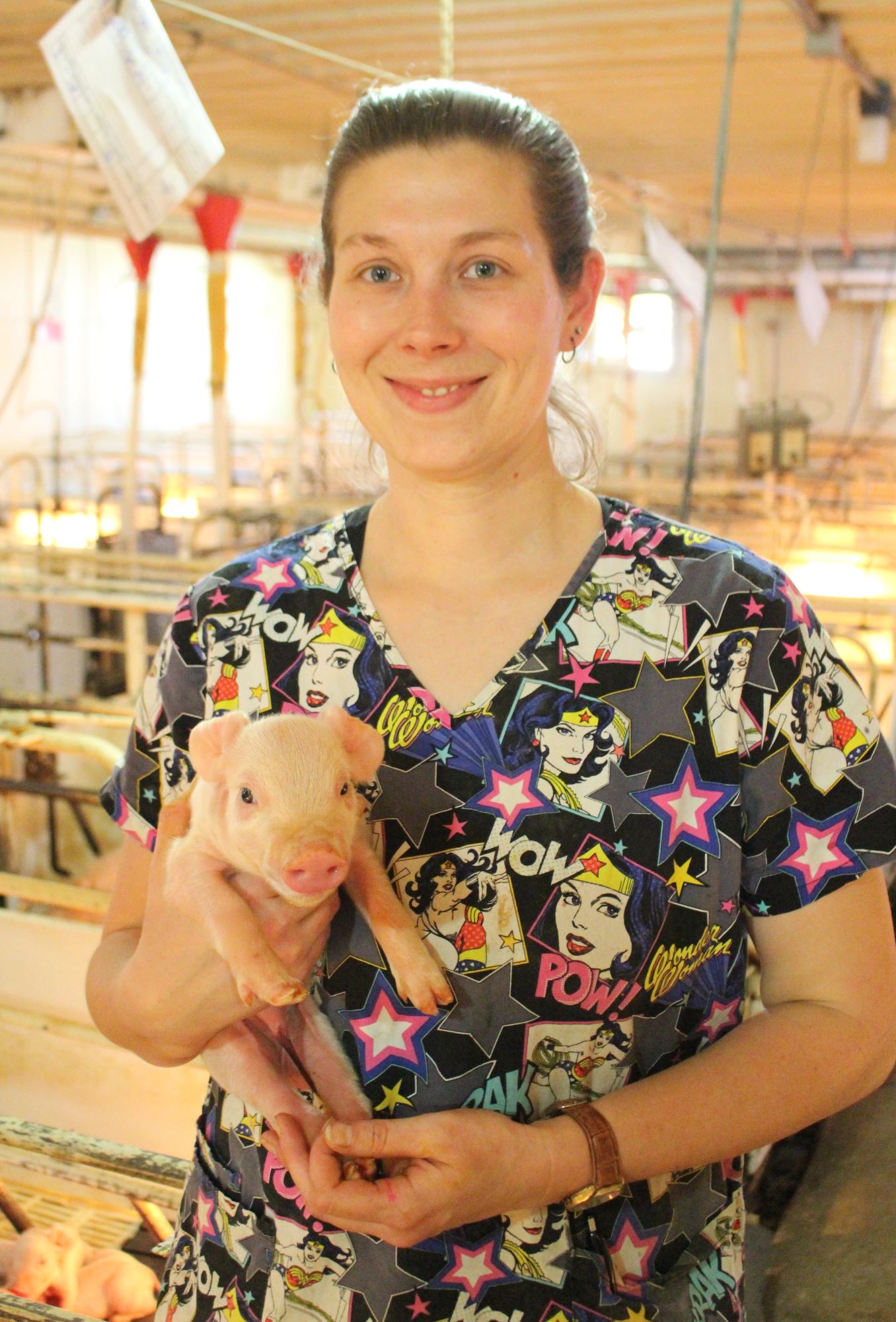 sarah holds a piglet